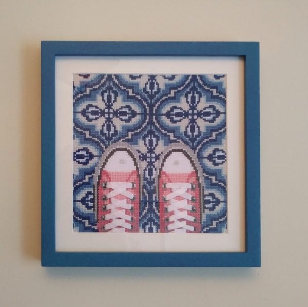 A cross stitch in a blue frame